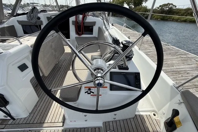Slide: The Image of Steering wheel of 2022 Jeanneau Sun Odyssey 410 sailboat, docked by the water. - 9