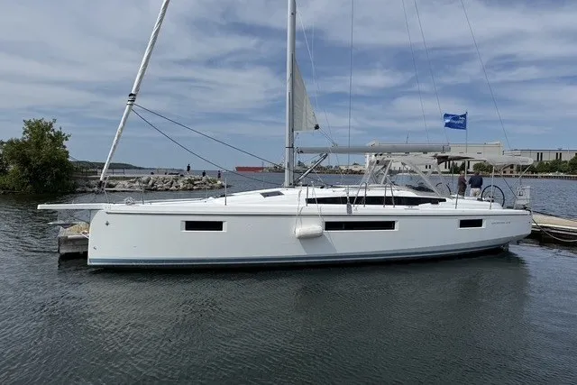 Slide: The Image of 2022 Jeanneau Sun Odyssey 410 sailboat docked in a serene marina setting. - 2