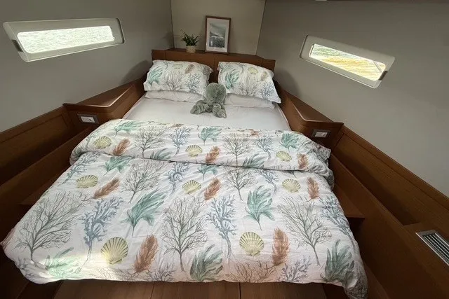 Slide: The Image of Cozy cabin interior of 2022 Jeanneau Sun Odyssey 410 with nautical-themed bedding. - 46