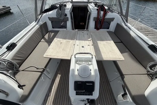 Slide: The Image of 2022 Jeanneau Sun Odyssey 410 cockpit with seating, table, and navigation equipment. - 8