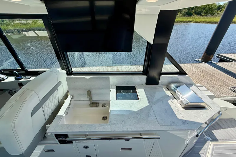 Slide: The Image of Luxurious 2023 Regal 36 XO yacht interior with modern kitchenette and scenic water view. - 20