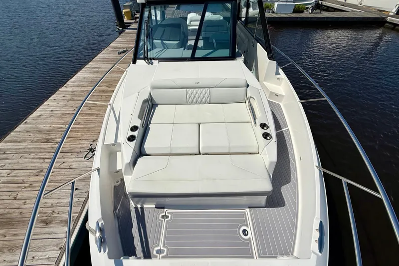 Slide: The Image of 2023 Regal 36 XO boat docked, featuring spacious white seating and sleek design. - 29