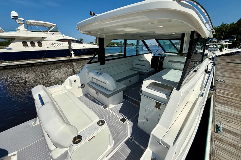 Slide: The Image of 2023 Regal 36 XO luxury yacht interior with spacious seating and modern design at a marina. - 14