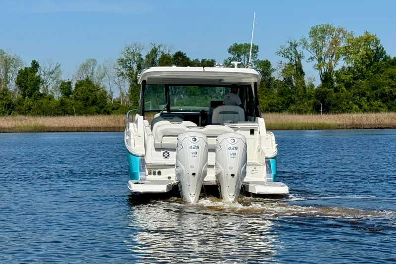 Slide: The Image of 2023 Regal 36 XO boat with dual 425 V8 engines cruising on a serene lake. - 3