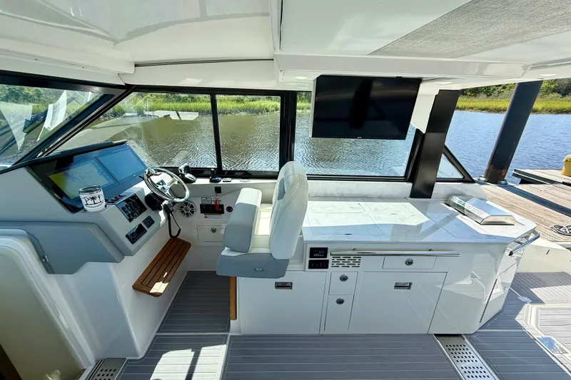 Slide: The Image of 2023 Regal 36 XO yacht helm with modern controls and panoramic water view. - 19