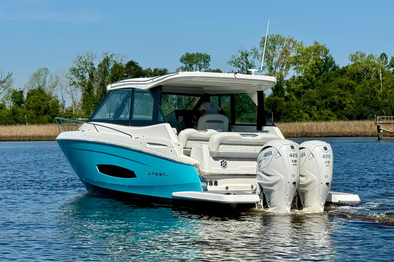 Slide: The Image of 2023 Regal 36 XO boat with dual Yamaha 425 engines on a serene lake. - 2