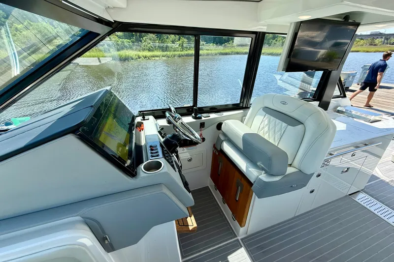 Slide: The Image of Interior of 2023 Regal 36 XO yacht with helm, seating, and water view. - 21