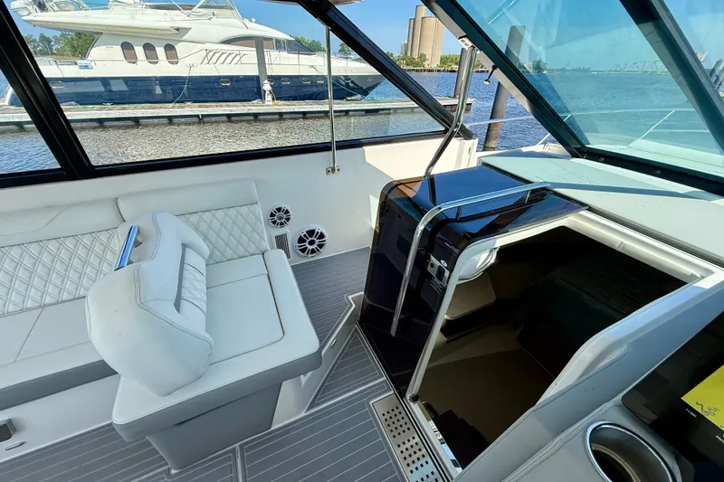 Slide: The Image of 2023 Regal 36 XO yacht interior with white seating and cabin entrance. - 26
