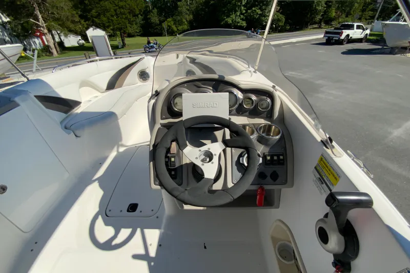 Slide: The Image of 2010 Hurricane SunDeck Sport 200 OB boat cockpit with steering wheel and controls. - 11