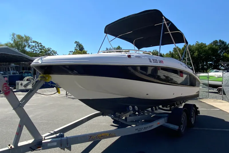 Slide: The Image of 2010 Hurricane SunDeck Sport 200 OB boat on trailer, parked outdoors under clear blue sky. - 5