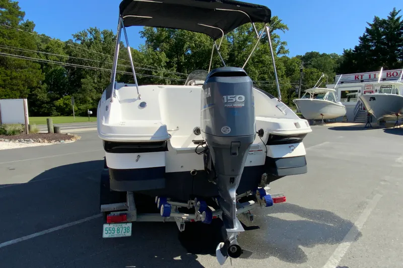 Slide: The Image of 2010 Hurricane SunDeck Sport 200 OB boat with Yamaha 150 engine, parked outdoors. - 8
