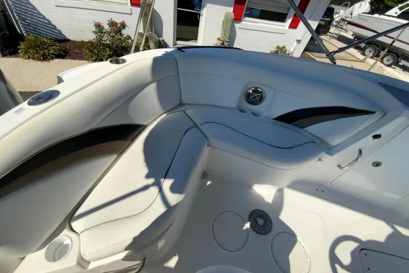 Slide: The Image of 2010 Hurricane SunDeck Sport 200 OB boat interior with white seating and cup holders. - 12