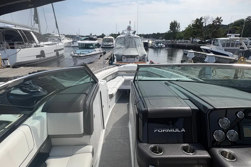Slide: The Image of 2018 Formula 330 Crossover Bowrider I/O docked at a marina with other boats. - 15