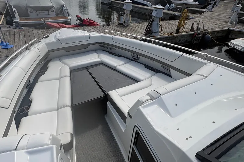 Slide: The Image of 2018 Formula 330 Crossover Bowrider I/O with spacious seating at a marina dock. - 16