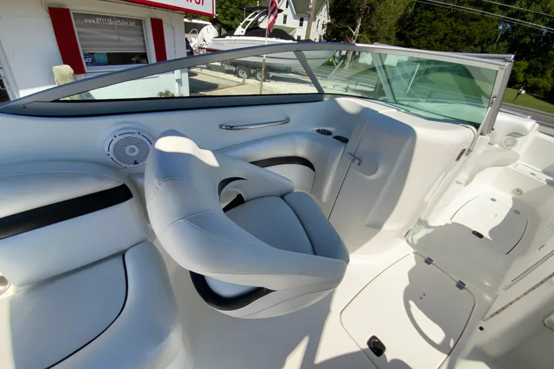 Slide: The Image of 2013 Hurricane SunDeck 2400 OB boat interior with white seating and speaker. - 18