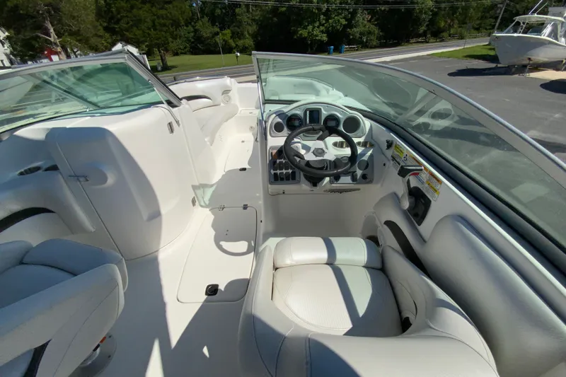 Slide: The Image of 2013 Hurricane SunDeck 2400 OB boat interior with steering wheel and seating. - 12