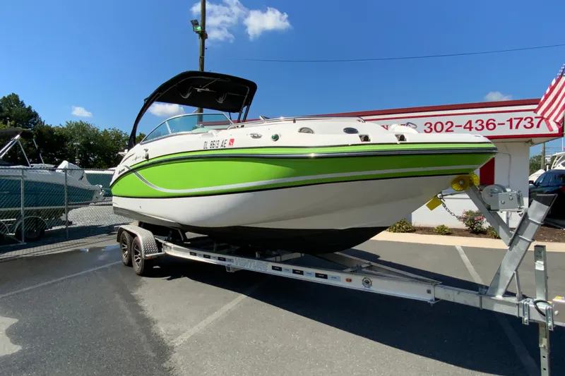 Slide: The Image of 2013 Hurricane SunDeck 2400 OB boat on trailer, vibrant green and white design. - 3