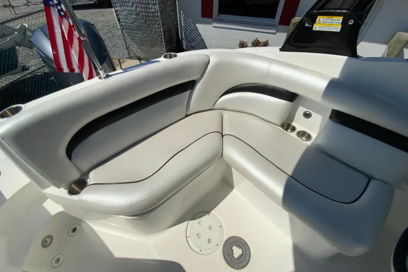Slide: The Image of 2013 Hurricane SunDeck 2400 OB boat interior with white seating and cup holders. - 17