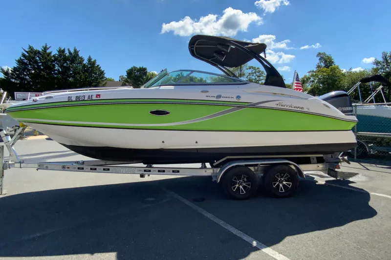 Slide: The Image of 2013 Hurricane SunDeck 2400 OB boat on trailer, vibrant green and white design. - 7
