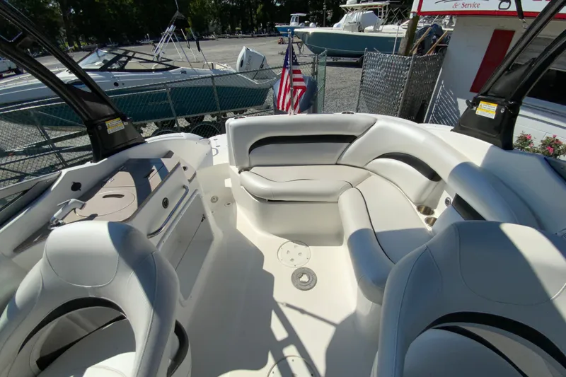 Slide: The Image of 2013 Hurricane SunDeck 2400 OB boat interior with seating and American flag in background. - 15