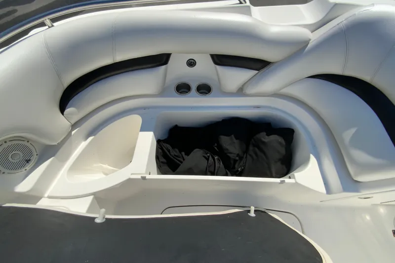 Slide: The Image of 2013 Hurricane SunDeck 2400 OB boat interior with white seating and storage compartment. - 26