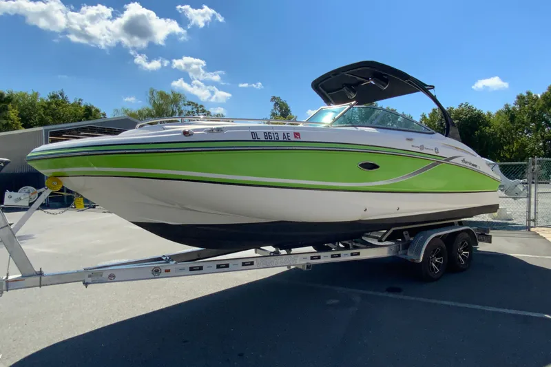 Slide: The Image of 2013 Hurricane SunDeck 2400 OB boat on trailer, vibrant green and white design. - 6