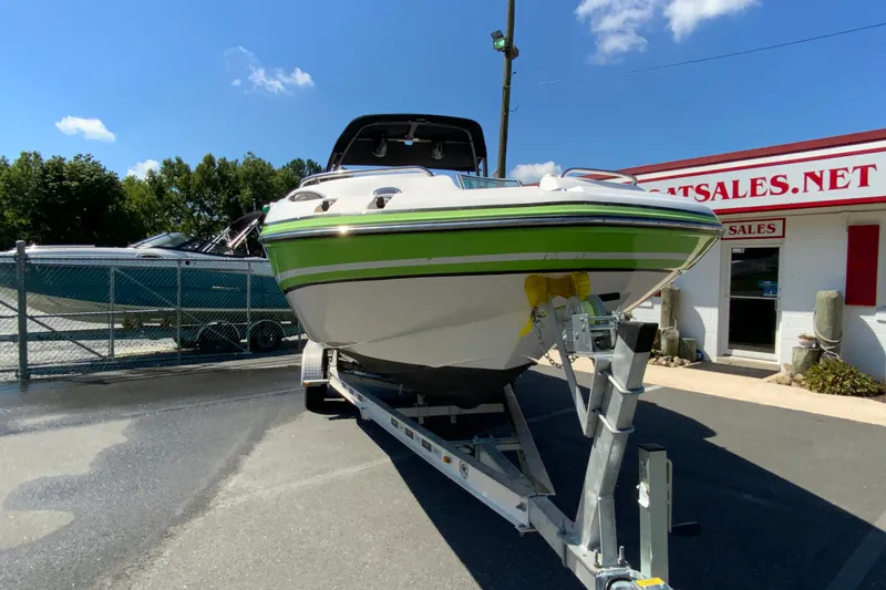 Slide: The Image of 2013 Hurricane SunDeck 2400 OB boat on trailer at dealership under clear blue sky. - 4