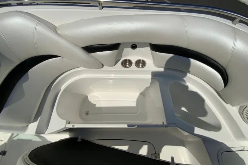 Slide: The Image of 2013 Hurricane SunDeck 2400 OB boat interior with white seating and storage compartment. - 25