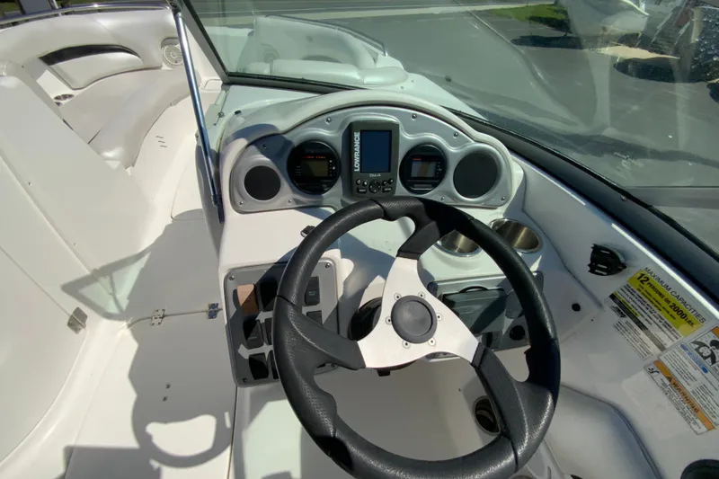 Slide: The Image of 2013 Hurricane SunDeck 2400 OB boat dashboard with steering wheel and navigation controls. - 13