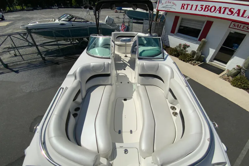 Slide: The Image of 2013 Hurricane SunDeck 2400 OB boat with spacious seating, displayed at a boat sales location. - 27
