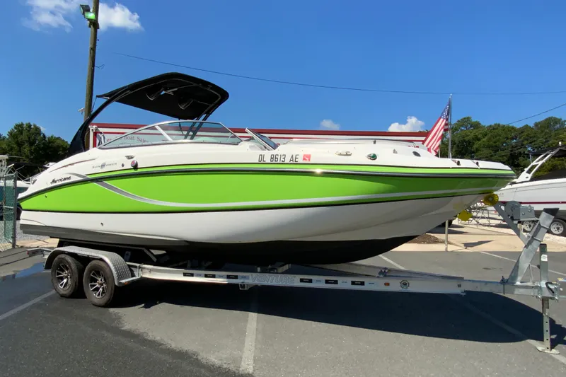 Slide: The Image of 2013 Hurricane SunDeck 2400 OB boat on trailer, vibrant green and white design. - 2