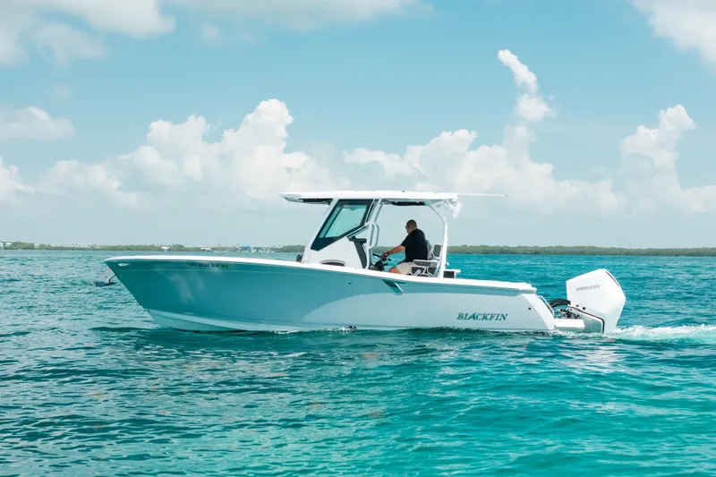 Slide: The Image of 2023 Blackfin 272 CC boat cruising on clear blue water under a sunny sky. - 42