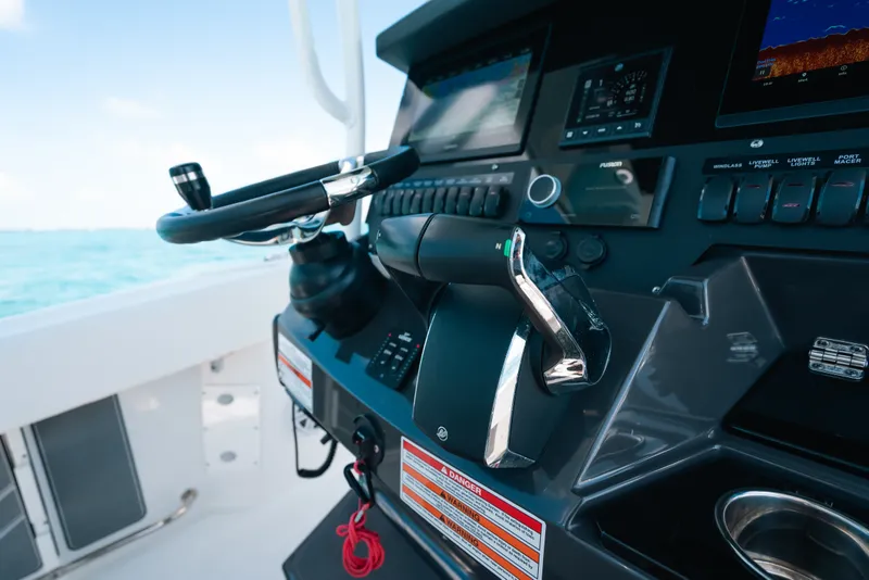 Slide: The Image of 2023 Blackfin 272 CC boat dashboard with steering wheel and control panel. - 63