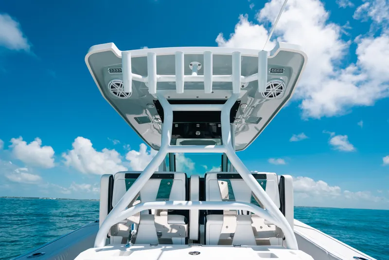 Slide: The Image of 2023 Blackfin 272 CC boat with T-top against blue sky and ocean backdrop. - 98