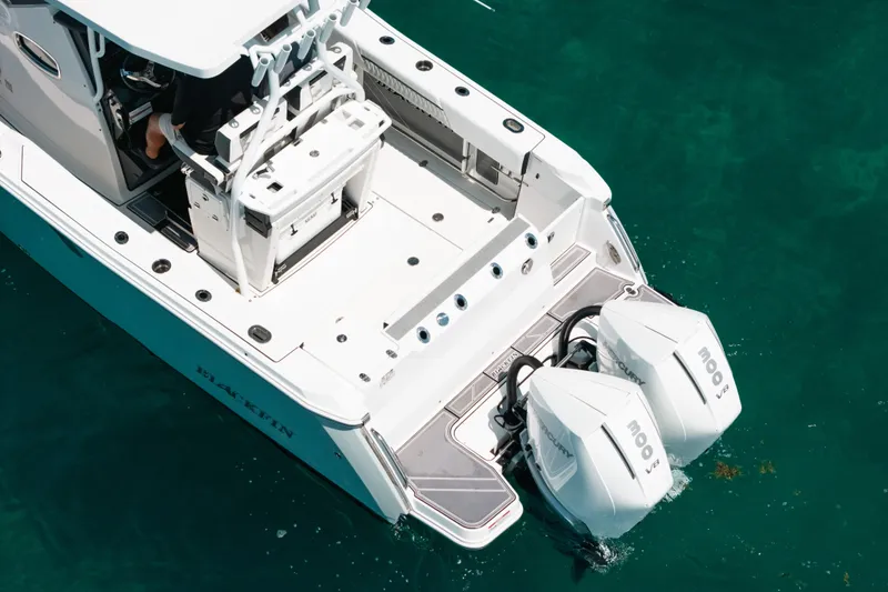 Slide: The Image of 2023 Blackfin 272 CC boat with dual outboard engines on clear water. - 85