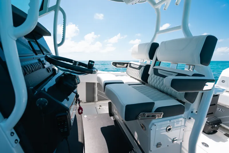 Slide: The Image of 2023 Blackfin 272 CC boat interior with modern seating and steering, ocean view. - 16