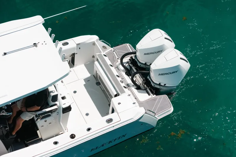 Slide: The Image of 2023 Blackfin 272 CC boat with dual Mercury engines on turquoise water. - 40