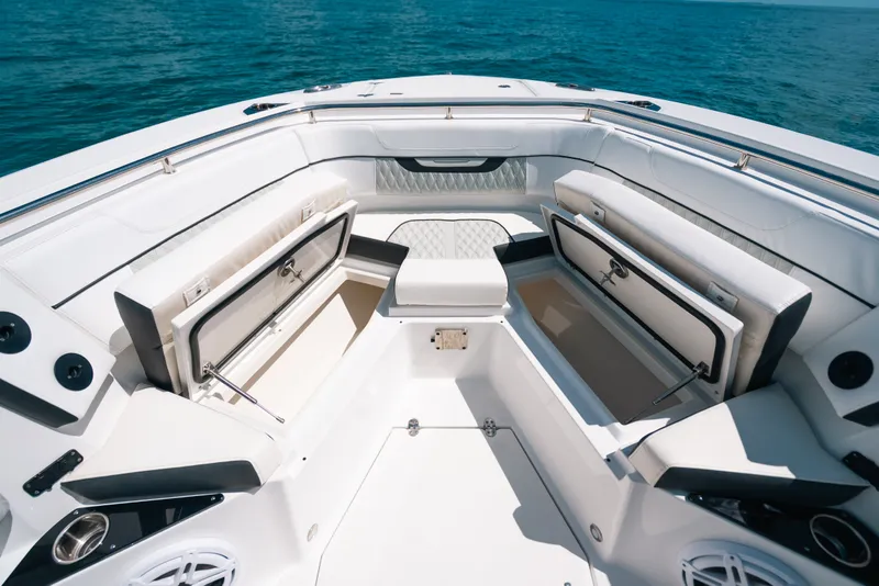 Slide: The Image of 2023 Blackfin 272 CC boat interior with open storage compartments, on calm blue water. - 69