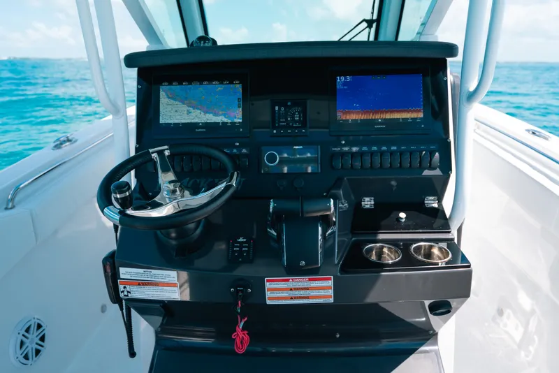 Slide: The Image of 2023 Blackfin 272 CC boat dashboard with navigation screens and steering wheel. - 107