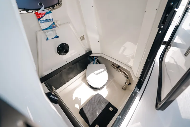 Slide: The Image of 2023 Blackfin 272 CC boat interior with compact marine toilet and storage space. - 97