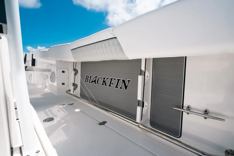 Slide: The Image of 2023 Blackfin 272 CC boat deck with logo, under clear blue sky. - 60