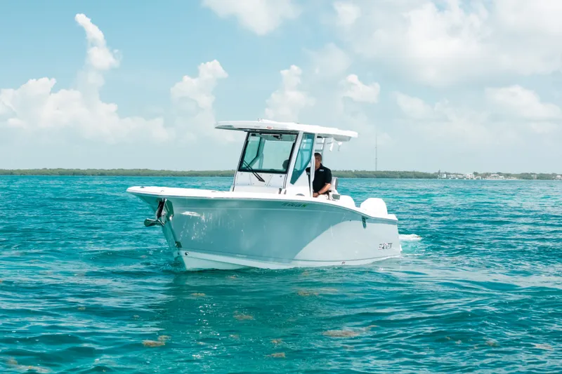 Slide: The Image of 2023 Blackfin 272 CC boat cruising on clear blue water under a sunny sky. - 89