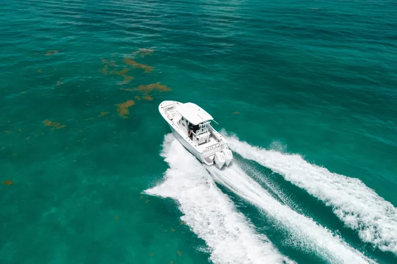 Slide: The Image of Aerial view of 2023 Blackfin 272 CC boat cruising on turquoise ocean waters. - 7
