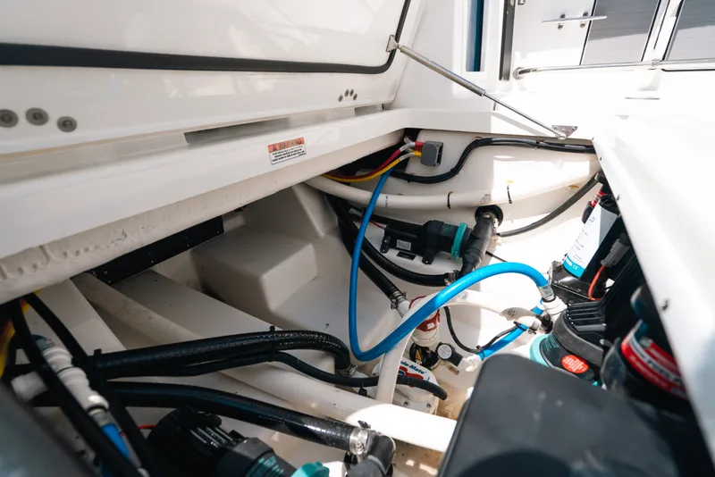 Slide: The Image of 2023 Blackfin 272 CC boat interior showing wiring and plumbing components. - 100