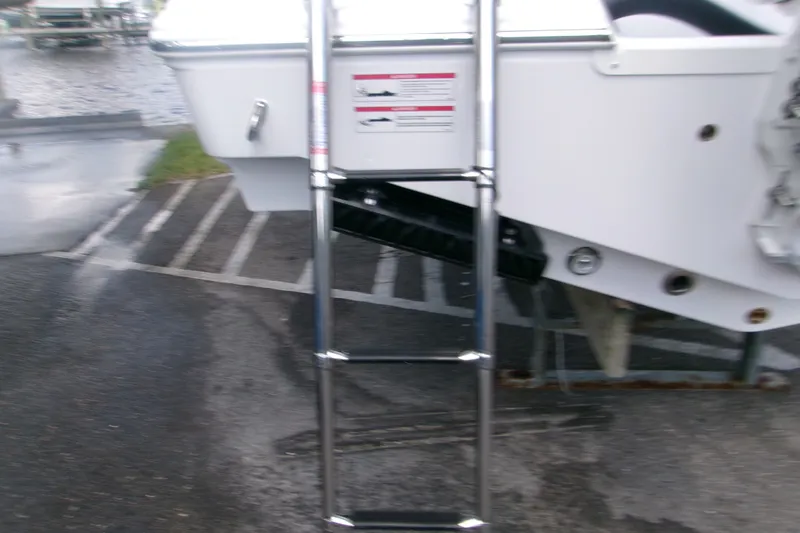 Slide: The Image of Ladder attached to 2027 Sportsman Open 232 Center Console boat on wet pavement. - 5
