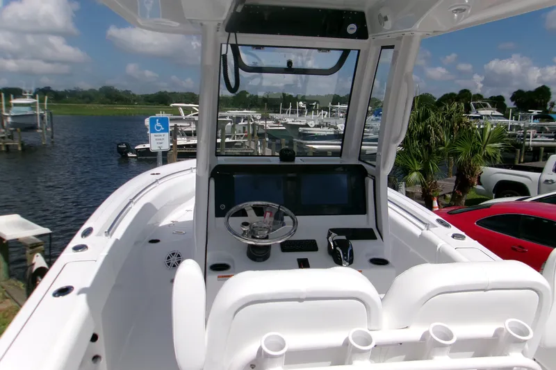 Slide: The Image of 2027 Sportsman Open 232 Center Console boat at marina, featuring modern helm and seating. - 7