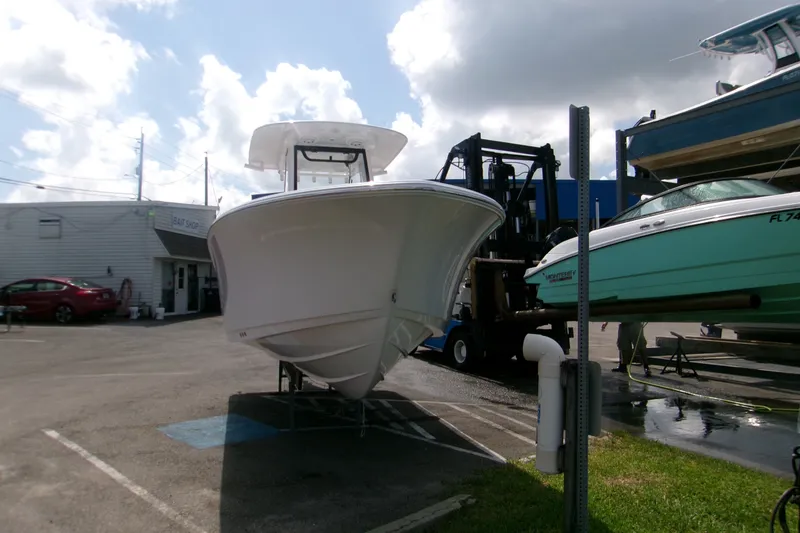 Slide: The Image of 2027 Sportsman Open 232 Center Console boat in a marina parking area. - 1