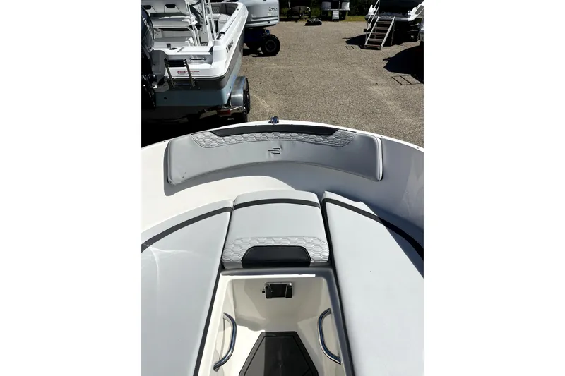 Slide: The Image of 2024 Bayliner Element M17 boat interior with cushioned seating and storage area. - 2
