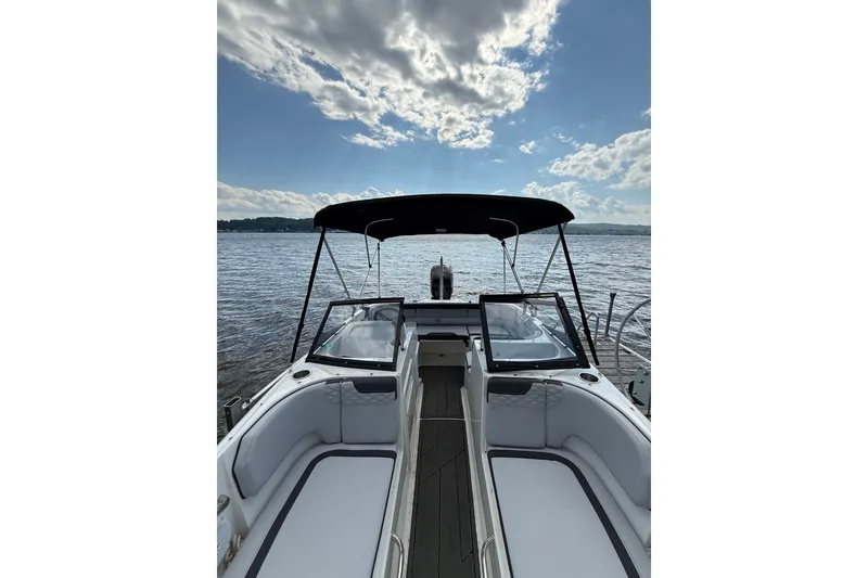 Slide: The Image of 2024 Bayliner Element M17 boat on calm water under a partly cloudy sky. - 3