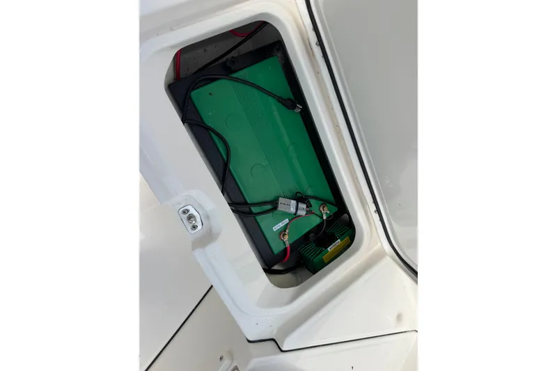 Slide: The Image of Battery compartment of 2026 Solace 32CS boat, featuring green battery and wiring. - 22